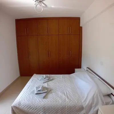 a bedroom with a white bed with wooden cabinets at Dioni of Rhodes in Rhodes Town
