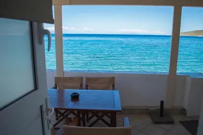 a table and chairs on a balcony overlooking the ocean at Sunrise Apartments in Livadia