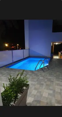 a swimming pool at night with a blue light at CARISSA SUITES a in Afantou