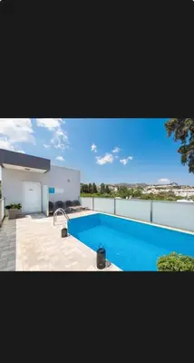 a large swimming pool in front of a house at CARISSA SUITES a in Afantou