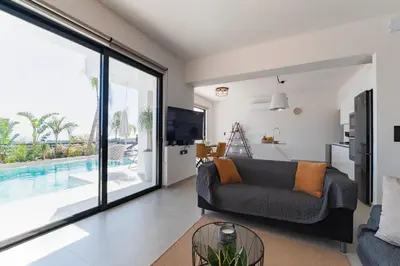 a living room with a couch and a large window at Blue Hills Villa in Kallithea Rhodes