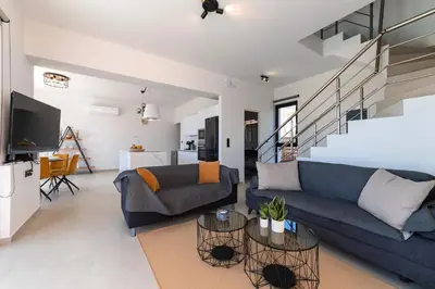 a living room with a blue couch and a tv at Blue Hills Villa in Kallithea Rhodes