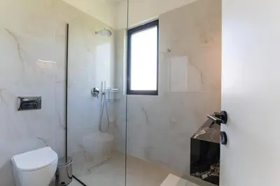a bathroom with a toilet and a glass shower at Blue Hills Villa in Kallithea Rhodes