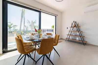 a dining room with a table and chairs and a large window at Blue Hills Villa in Kallithea Rhodes