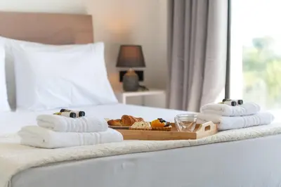 a tray of towels and a tray of food on a bed at Blue Hills Villa in Kallithea Rhodes