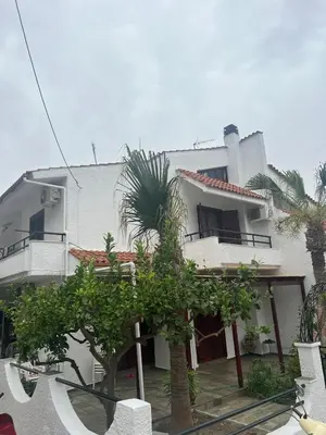 a white house with palm trees in front of it at Bella Vita Ixia in Ixia