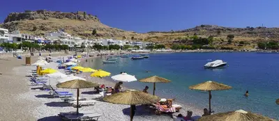 a beach with many umbrellas and people on the beach at néreya luxury rooms in Haraki
