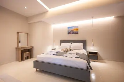 a bedroom with a large bed with white sheets at Blue Wave Suites - Ixia in Ialyssos