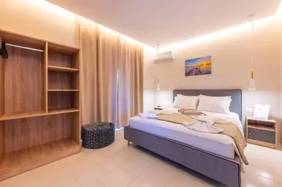 a bedroom with a bed and a book shelf at Blue Wave Suites - Ixia in Ialyssos