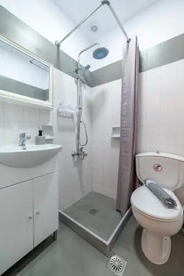 a bathroom with a toilet and a sink and a shower at Blue Wave Suites - Ixia in Ialyssos
