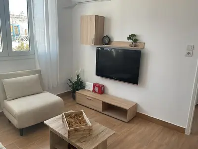 a living room with a flat screen tv on a wall at Telis House in Rhodes Town