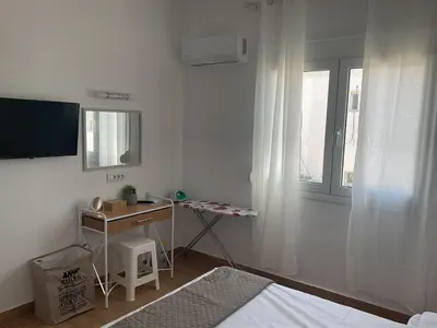 a bedroom with a bed and a desk and a television at Telis House in Rhodes Town