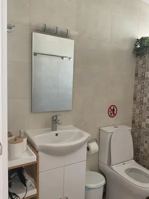 a bathroom with a sink and a toilet and a mirror at Telis House in Rhodes Town