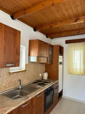 a kitchen with wooden cabinets and a sink at Levante Apartment for 4 in Faliraki