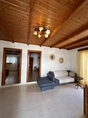 a bedroom with a bed and a couch and wooden ceilings at Levante Apartment for 4 in Faliraki