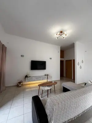 a living room with a couch and a tv on the wall at Amelia's Home in Symi