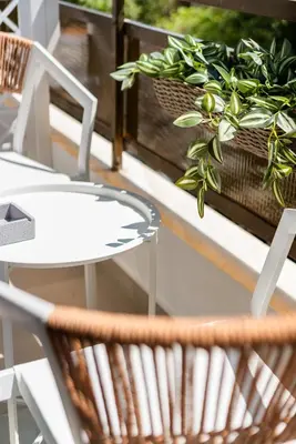 a white table and chairs on a balcony with a potted plant at Cozy Suite in Rhodes Town