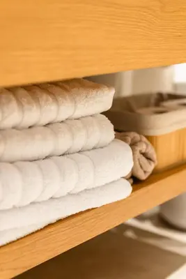 a stack of white towels on a shelf at Cozy Suite in Rhodes Town