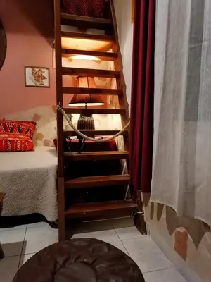 a wooden staircase in a room with a bed at Bersimi Lazaridis in Rhodes Town