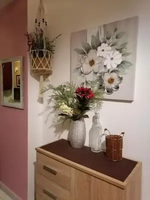 a dresser with flowers in a vase on it at Bersimi Lazaridis in Rhodes Town