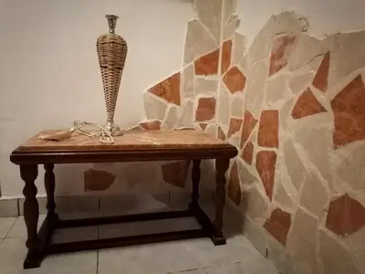 a table with a vase on it next to a stone wall at Bersimi Lazaridis in Rhodes Town