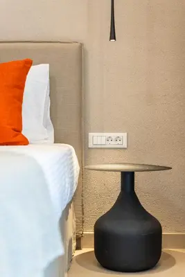 a black table next to a bed with a pillow at Stylish Suite in Rhodes Town