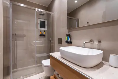 a bathroom with a white sink and a shower at Stylish Suite in Rhodes Town