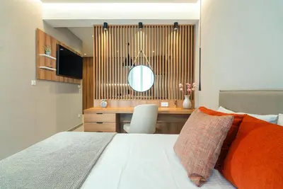 a bedroom with a bed and a desk with a mirror at Stylish Suite in Rhodes Town