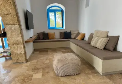 a living room with a couch and a window at Kertenia - Villa Vayu in Kattavía