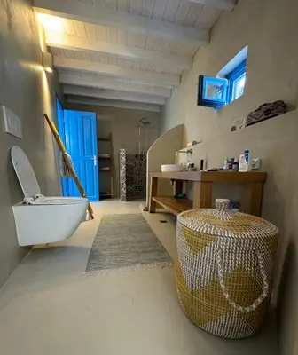 a bathroom with a white toilet and a sink at Kertenia - Villa Vayu in Kattavía