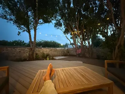 a person with their feet on a wooden bench at Kertenia - Villa Vayu in Kattavía