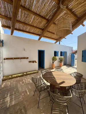 a patio with a wooden table and chairs at Kertenia - Villa Vayu in Kattavía