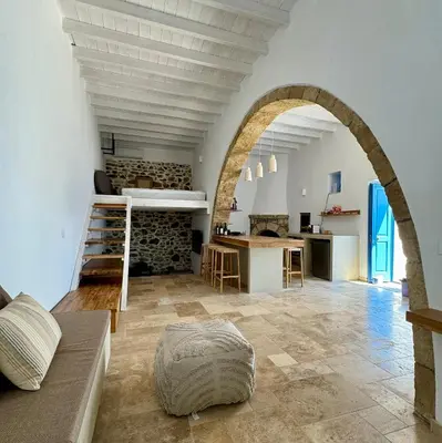 a large living room with an archway and a kitchen at Kertenia - Villa Vayu in Kattavía