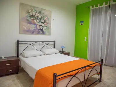 a bedroom with a bed and a painting on the wall at Village View Afandou in Afantou