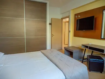 a bedroom with a bed and a desk and a television at Village View Afandou in Afantou