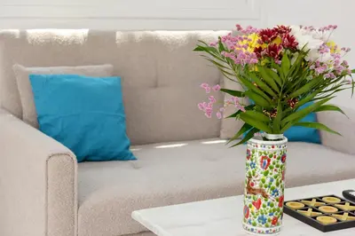 a vase of flowers on a coffee table in front of a couch at Liri family paradise Danis house in Ixia