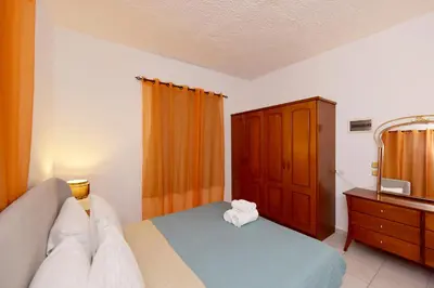 a bedroom with a bed and a dresser and a mirror at Liri family paradise Danis house in Ixia