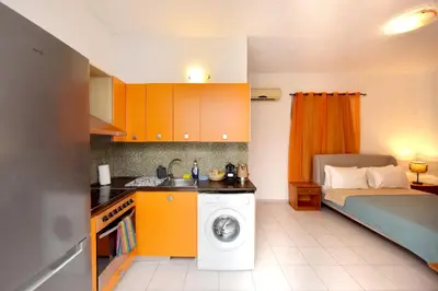 a kitchen with a washing machine and a bed at Liri family paradise Danis house in Ixia