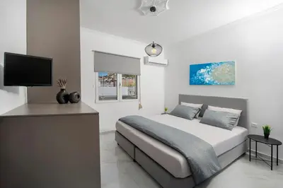 a bedroom with a bed and a flat screen tv at Sokrates Residence in Afantou