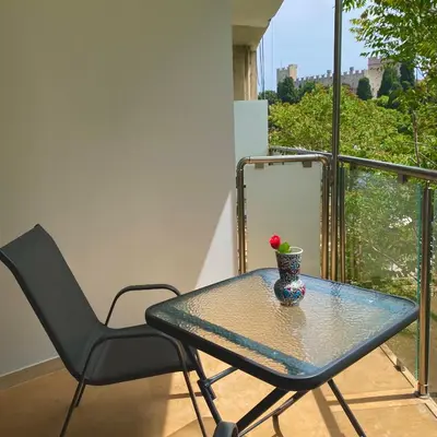 a glass table and a chair on a balcony at SEAL of Knight - Castle View - Downtown near the Beach in Rhodes Town