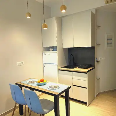 a small kitchen with a table and blue chairs at SEAL of Knight - Castle View - Downtown near the Beach in Rhodes Town