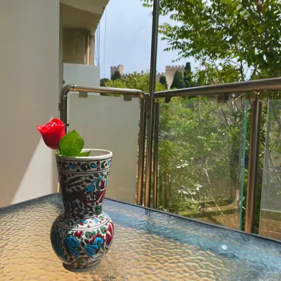 a vase with a rose in it sitting on a table at SEAL of Knight - Castle View - Downtown near the Beach in Rhodes Town