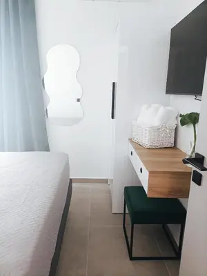 a bedroom with a bed and a desk with a tv at Azure Mirage Home Adults Only Private Seaside Villa w Garden and Parking in Faliraki