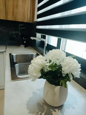 a white vase with white flowers on a kitchen counter at Azure Mirage Home Adults Only Private Seaside Villa w Garden and Parking in Faliraki