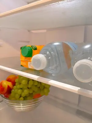 a refrigerator with a bottle of water and a bowl of fruit at Azure Mirage Home Adults Only Private Seaside Villa w Garden and Parking in Faliraki