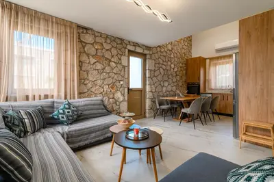 a living room with a couch and a table at Drakos Estate - Luxury Pool Villas in Asgourou