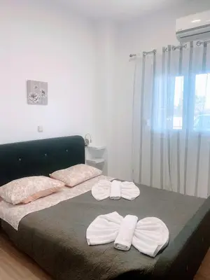 a bedroom with a bed with two towels on it at MariAggela's Cosy House in Theologos