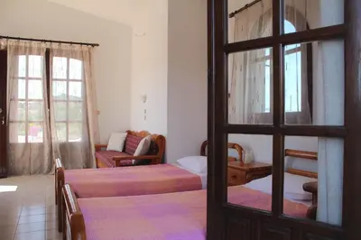 a bedroom with two beds and a living room at Sunset Beach Studio in Kremasti