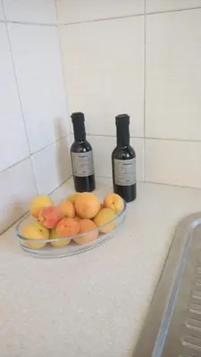 two bottles of wine and a plate of fruit on a counter at Sunset Beach Studio in Kremasti