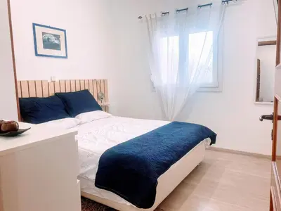 a bedroom with a bed with a blue blanket on it at MariAggela's Little House in Theologos